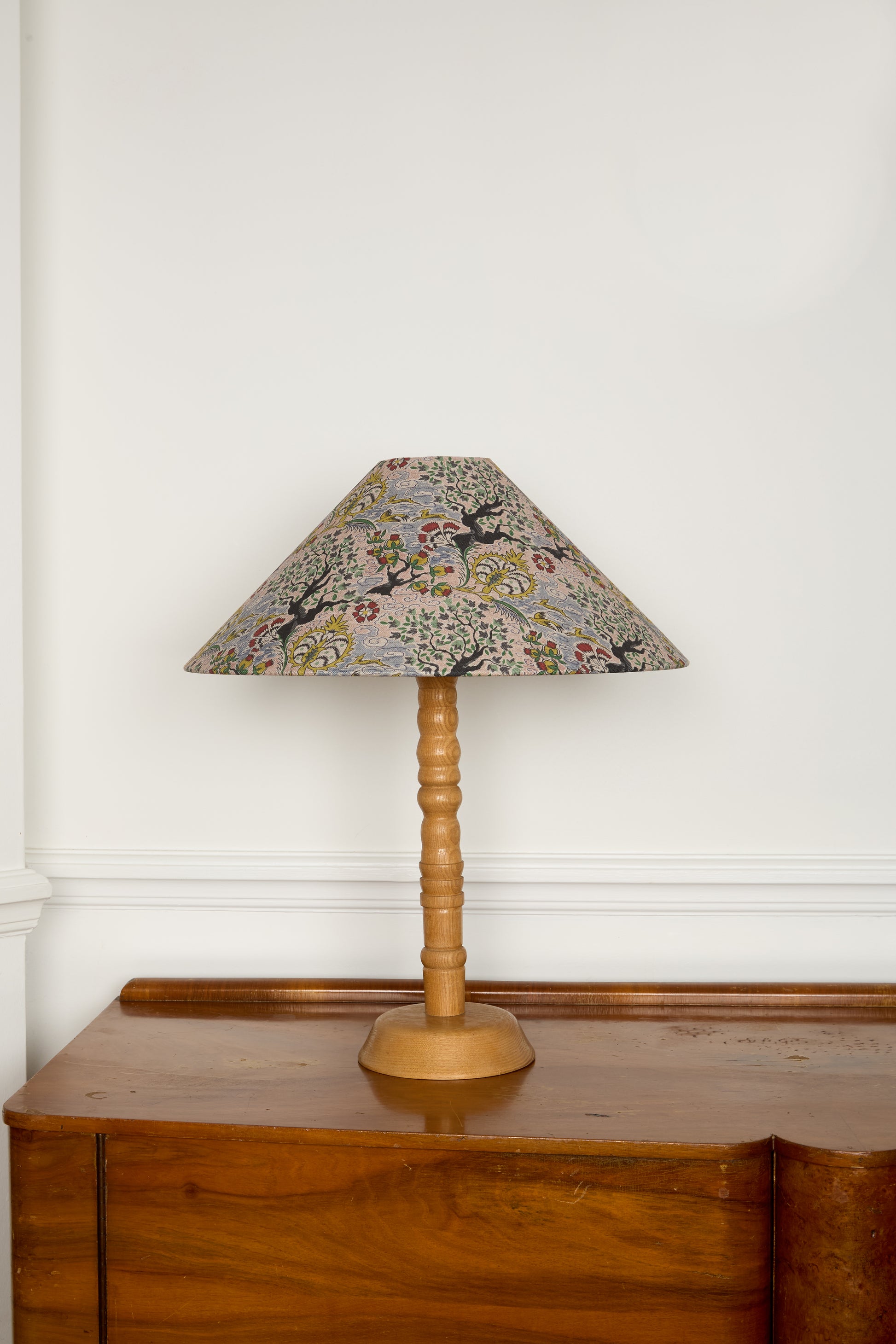 Table lamp with floral patterned shade on a wooden surface
